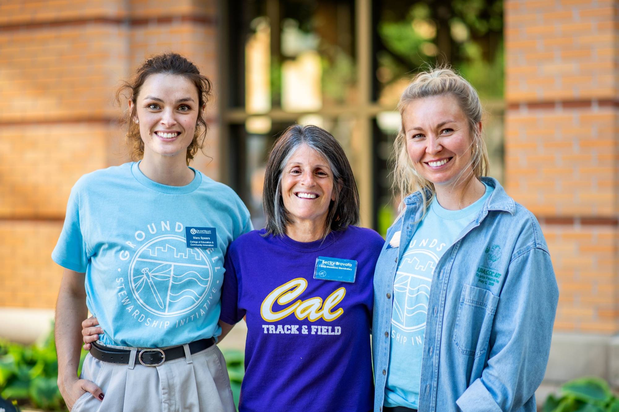 Groundswell staff standing with an educator smiling